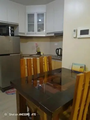 a kitchen with a table with chairs and a sink at Walkable to and from NAIA 3 and Resorts World in Manila