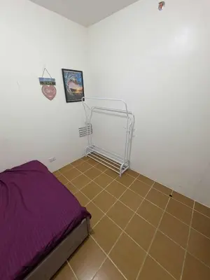 a bedroom with a bed and a tiled floor at Lily s Place in Manila