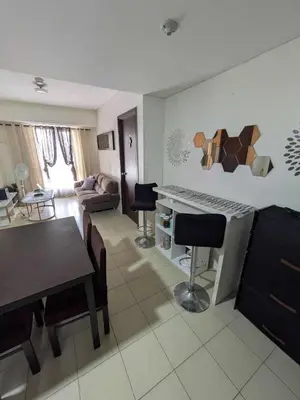 a kitchen and living room with a table and chairs at Lily s Place in Manila
