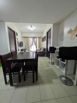 a living room with a dining room table and chairs at Lily s Place in Manila
