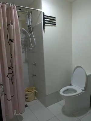 a bathroom with a toilet and a shower with a shower curtain at Lily s Place in Manila