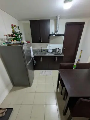 a small kitchen with a sink and a table at Lily s Place in Manila