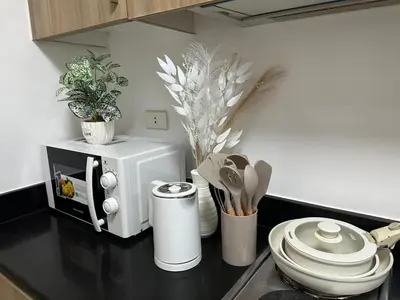 a kitchen counter with a microwave and some plants at The City View Air Residences Makati in Manila