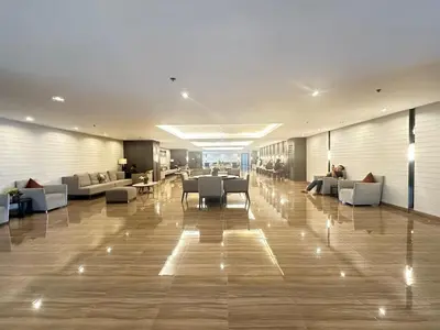 a lobby with couches and tables in a building at The City View Air Residences Makati in Manila