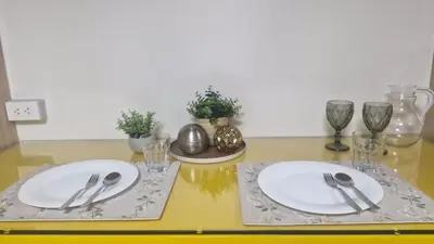a table with two white plates and silverware on it at Kage-no-Wa Suite Netflix, Disney, HBO 2BR in Manila