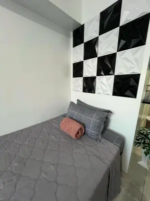 a bedroom with a bed and a checkered wall at SM Jazz Residences, Makati City in Manila