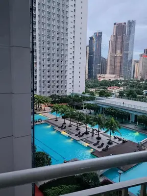 a view of a pool with palm trees and a building at SM Jazz Residences, Makati City in Manila