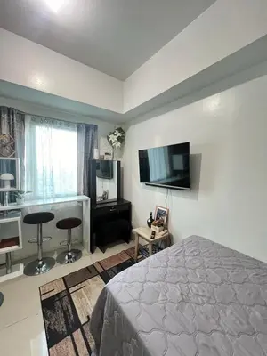 a bedroom with a bed and a flat screen tv at SM Jazz Residences, Makati City in Manila