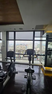 a gym with two exercise bikes and a view of the city at Urban Retreat at The Gramercy Residences Makati in Manila