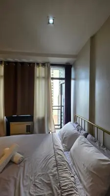a large bed in a bedroom with a window at Urban Retreat at The Gramercy Residences Makati in Manila