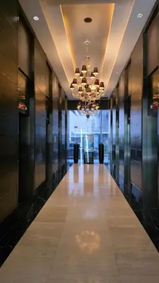 a hallway in a building with a chandelier at Urban Retreat at The Gramercy Residences Makati in Manila