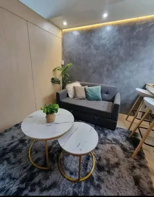a living room with a couch and two tables at cozy room at Sea Res in Manila