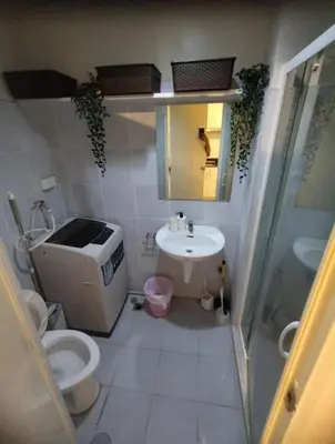 a small bathroom with a toilet and a sink at cozy room at Sea Res in Manila