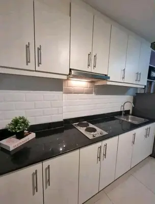 a kitchen with white cabinets and a sink at cozy room at Sea Res in Manila