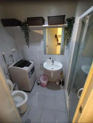 a small bathroom with a toilet and a sink at cozy room at Sea Res in Manila