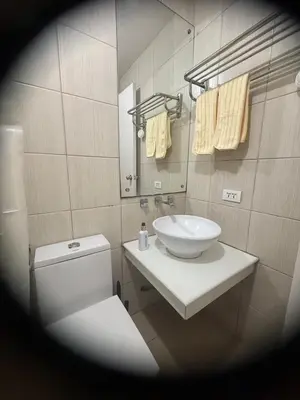 a bathroom with a sink and a toilet and a mirror at TGG Suites at Birch Tower in Manila