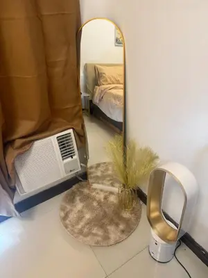 a bedroom with a mirror and a bed and a fan at TGG Suites at Birch Tower in Manila