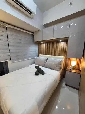 a bedroom with a large bed with a black object on it at Cozy Haven Suite at Shore 3 in Manila