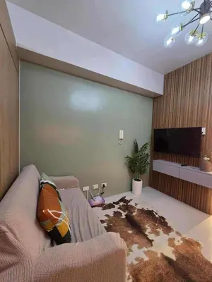 a living room with a couch and a flat screen tv at Cozy Haven Suite at Shore 3 in Manila