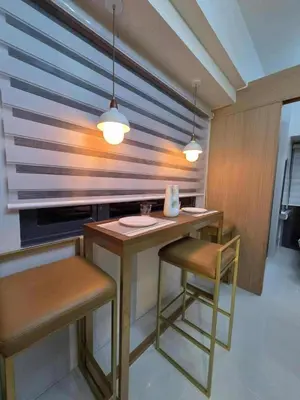 a kitchen with a table with two chairs and two lights at Cozy Haven Suite at Shore 3 in Manila