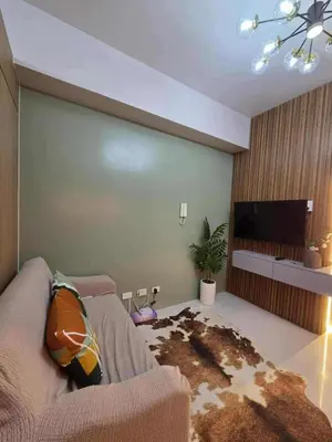 a living room with a couch and a flat screen tv at Cozy Haven Suite at Shore 3 in Manila