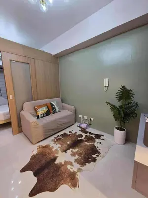 a bedroom with a bed and a rug with a map at Cozy Haven Suite at Shore 3 in Manila