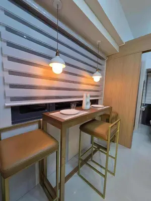 a kitchen with a table with two chairs and two lights at Cozy Haven Suite at Shore 3 in Manila