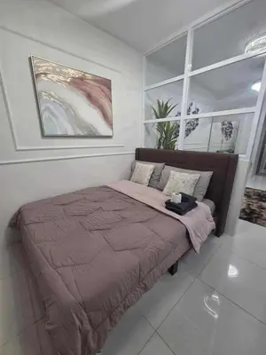 a large bed in a bedroom with a large window at City Escape Haven in Manila