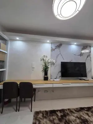 a desk with a computer and two chairs in a room at City Escape Haven in Manila
