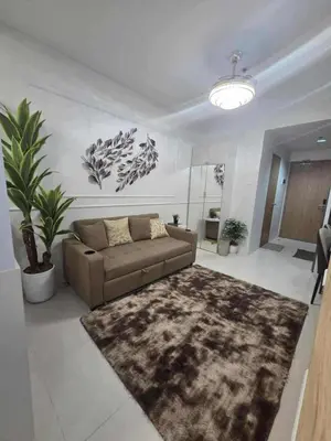 a living room with a couch and a rug at City Escape Haven in Manila