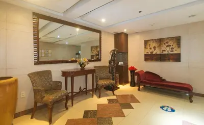 a waiting room with chairs and a table and a mirror at The Shilla Philia Hotel by RedDoorz in Manila