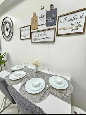 a dining room table with white plates on it at New Crib at Shore 3 in Manila
