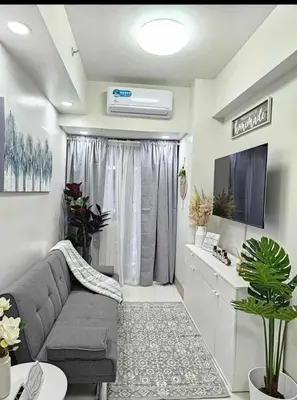 a living room with a gray couch and a tv at New Crib at Shore 3 in Manila