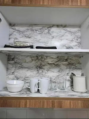 a shelf with cups and plates and glasses on it at New Crib at Shore 3 in Manila