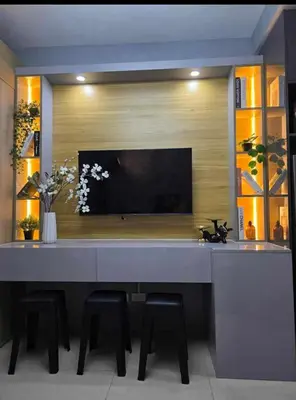 a living room with a large table with chairs and a television at Sakura Suite at Shore 2 in Manila