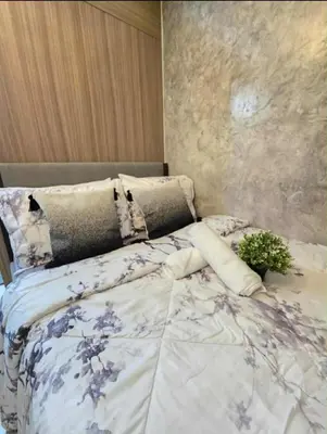 a bedroom with a large bed with blue and white sheets at Sakura Suite at Shore 2 in Manila