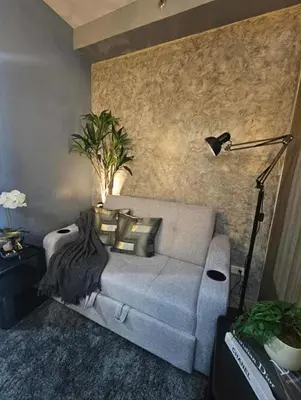 a living room with a couch and a lamp at Sakura Suite at Shore 2 in Manila