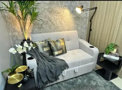 a living room with a white couch with gold pillows at Sakura Suite at Shore 2 in Manila