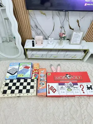 a pile of books sitting on a table with a chessboard at The Luxe Stay at Sea Residences in Manila