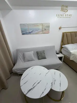 a living room with a table and a couch at The Luxe Stay at Sea Residences in Manila