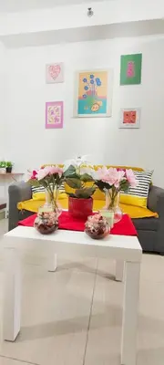 a white coffee table with flowers in vases on it at Stand out and cozy condo unit at Shore 2 Tower 3 in Manila