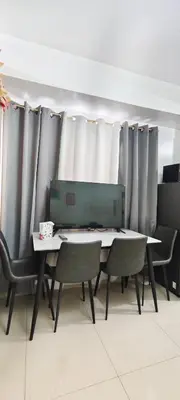 a table and chairs in a room with curtains at Stand out and cozy condo unit at Shore 2 Tower 3 in Manila