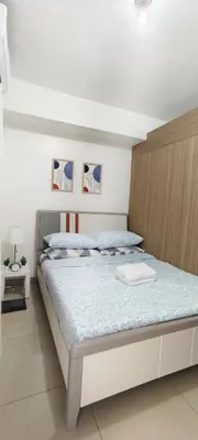 a bedroom with a bed with a wooden headboard at Stand out and cozy condo unit at Shore 2 Tower 3 in Manila