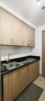 a kitchen with wooden cabinets and a sink at Stand out and cozy condo unit at Shore 2 Tower 3 in Manila