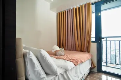 a bedroom with a bed and a window with a balcony at The Dream Scape SMDC Air Residences Makati in Manila