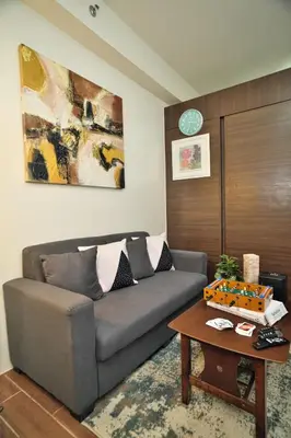 a living room with a couch and a table at The Dream Scape SMDC Air Residences Makati in Manila