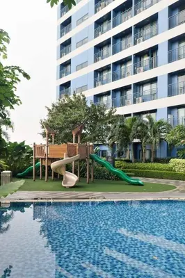 a playground in front of a building with a swimming pool at The Dream Scape SMDC Air Residences Makati in Manila