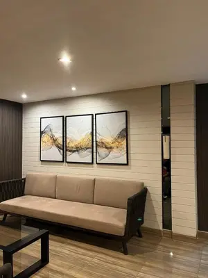 a couch in a room with three pictures on the wall at The Urban Crib SMDC Residences Makati in Manila