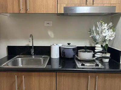 a kitchen counter with a sink and a stove at Sweet Villa SMDC Breeze Residences Pasay in Manila