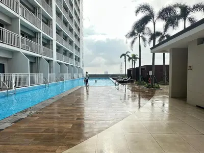 a person standing in a swimming pool in a hotel at Sweet Villa SMDC Breeze Residences Pasay in Manila